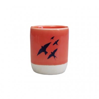 Vaso cilíndrico laranja e branco com pássaros pretos