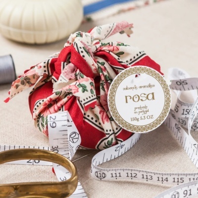 Sabonete aromático rosa em tecido decorado com fita métrica e tesoura.