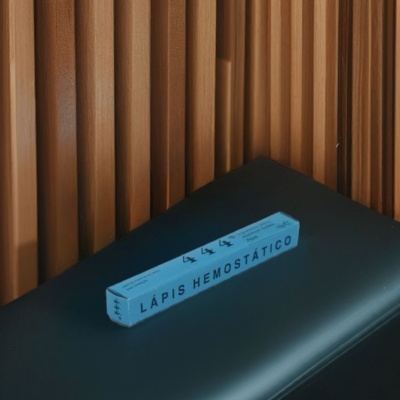 Caixa azul de lápis hemostático sobre cadeira preta com fundo de painéis de madeira