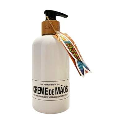 Frasco branco de creme de mãos com tampa doseadora preta e pendente com desenho colorido de peixe