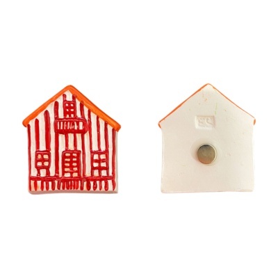 Dois ímanes cerâmicos em forma de casa com telhado laranja e padrões vermelhos
