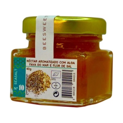 Frasco de vidro com néctar aromatizado, tampa dourada e etiqueta azul e branca.