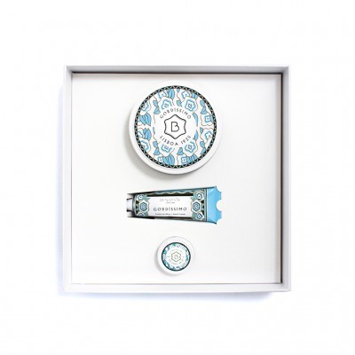 Três produtos cosméticos numa caixa branca com decoração azul e branca