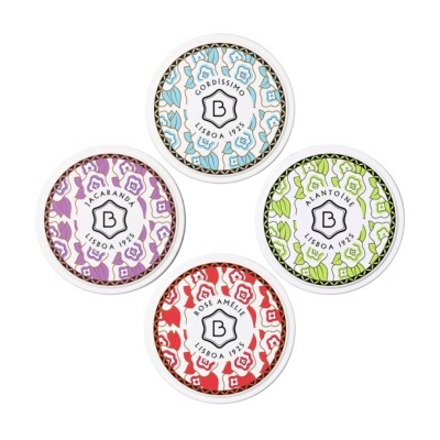 Quatro latas redondas decorativas com padrões florais em azul, lilás, verde e vermelho e texto central em português.