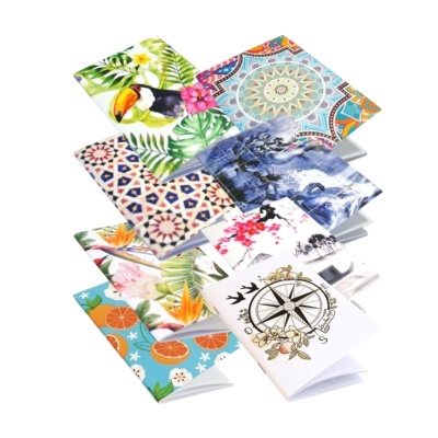Cadernos com capas decorativas variadas em padrões coloridos e desenhos temáticos.