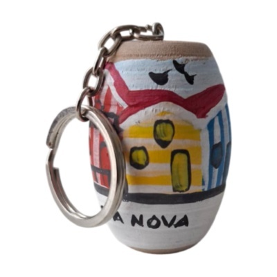 Llavero de cerámica con diseño pintado de casitas y cadena metálica.