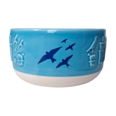 Taça de cerâmica azul com desenhos de aves e relevos brancos