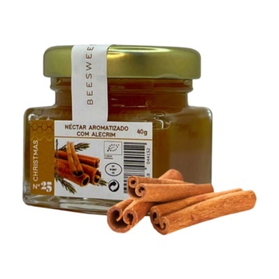 Frasco de néctar aromatizado com alecrim ao lado de paus de canela