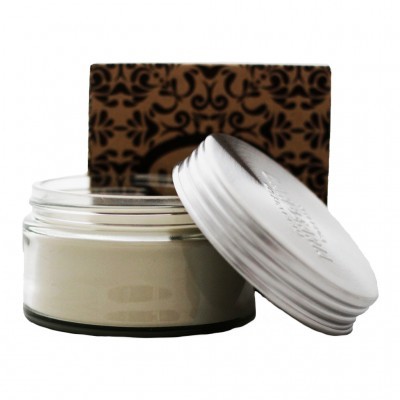 frasco de creme em vidro com tampa branca ao lado de caixa castanha com padrão preto