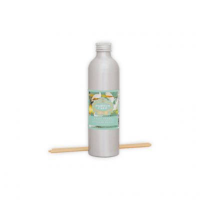 Garrafa prateada de aromatizador ambiente com rótulo azul e amarelo e pauzinhos de difusor