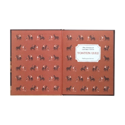 Livro aberto com padrão de desenhos de pessoas e burros em fundo castanho e texto TONTON LULU