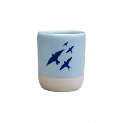 Copo cerâmico azul claro com aparência de pássaros azuis escuros