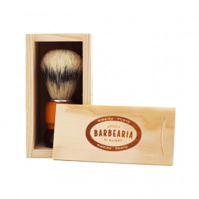 Pincel de barbear em caixa de madeira com texto impresso na tampa.