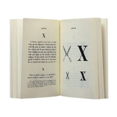 Livro aberto com texto e ilustrações da letra X e tesouras.