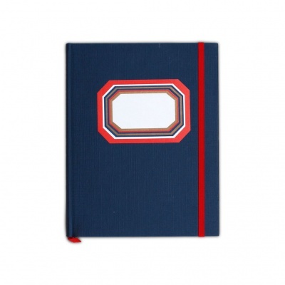 Caderno capa dura azul escuro com elástico vermelho e etiqueta octogonal no centro