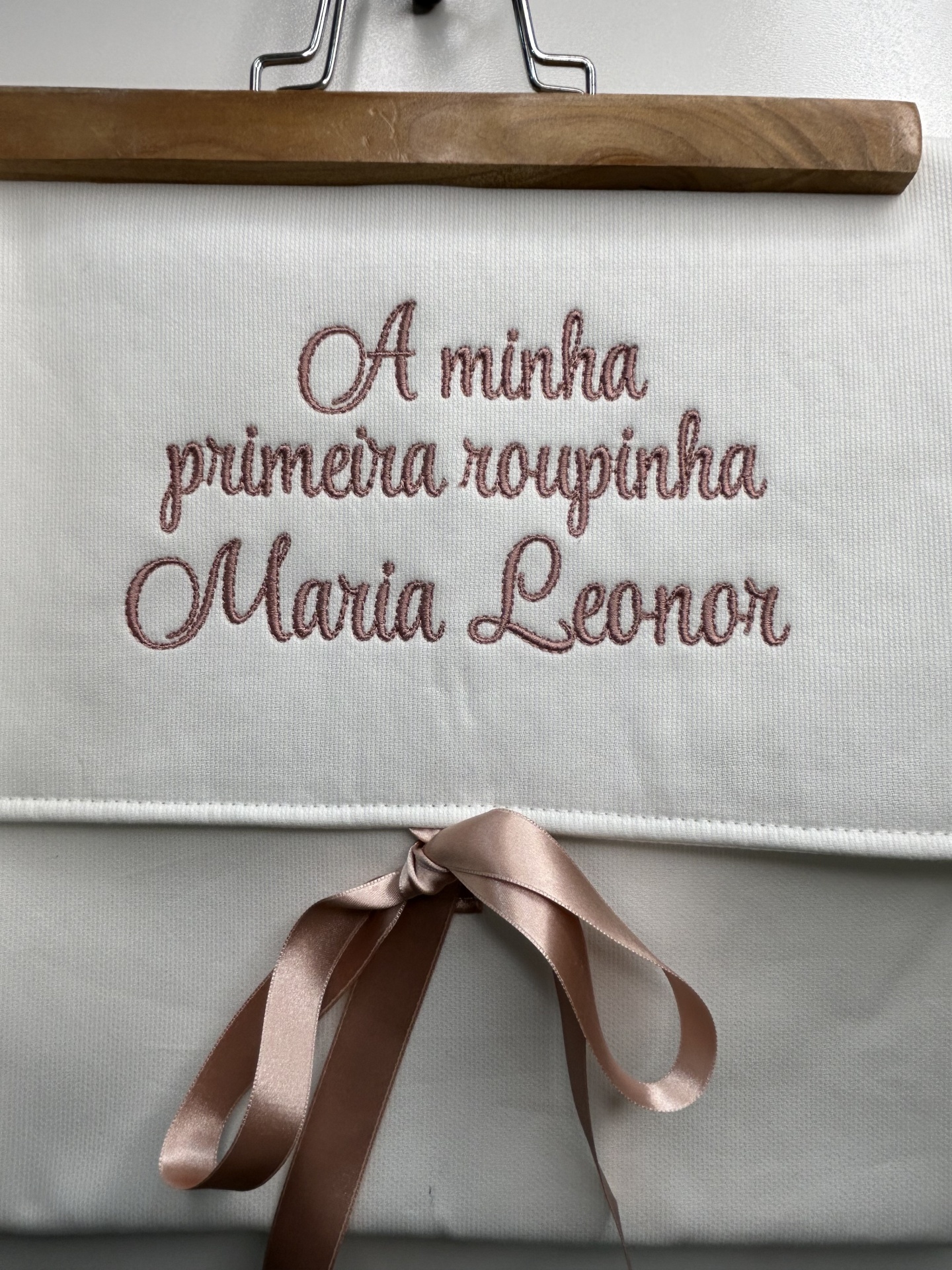 Saco branco bordado com texto cor-de-rosa e fita rosa amarrada em laço