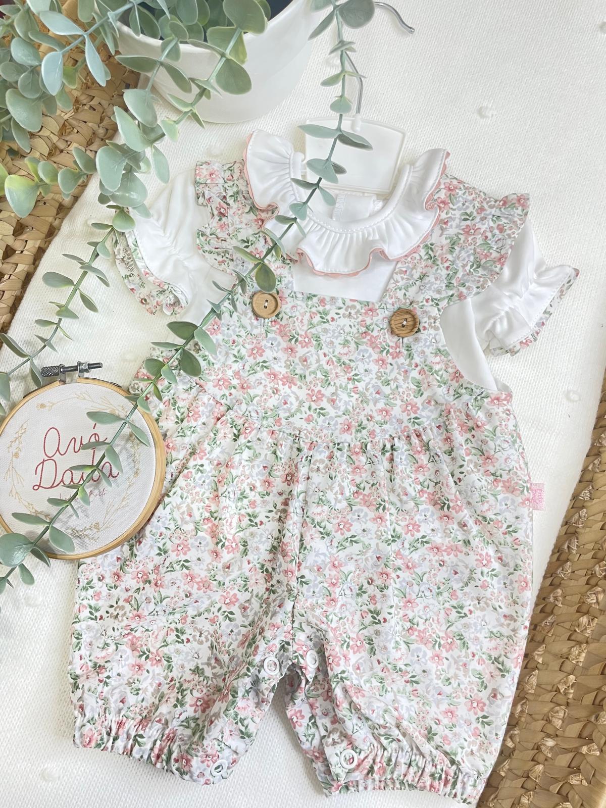 Conjunto de roupa de bebé branco e floral com botões de madeira.