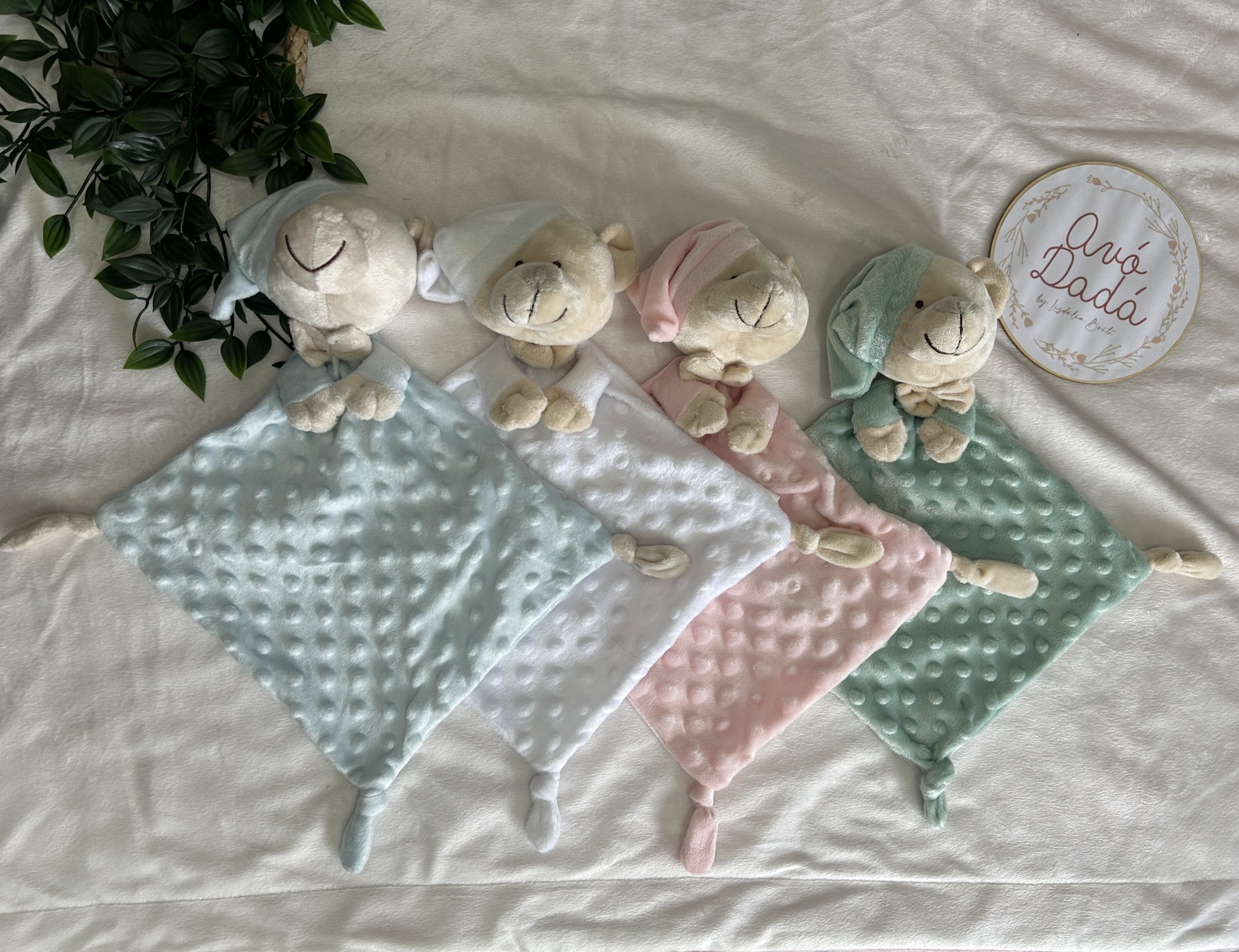 Quatro paninhos de gato de peluche coloridos com ursinhos e uma placa com texto em fundo branco