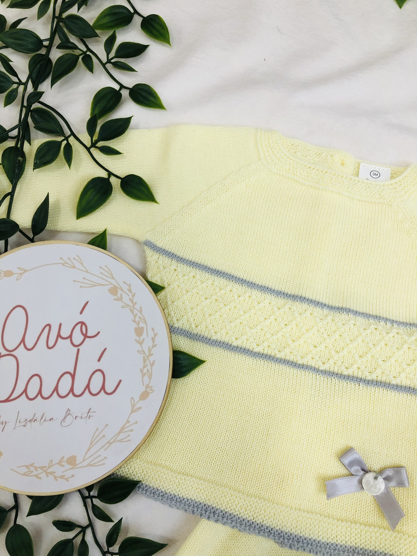 Camisola de bebé amarela com riscas cinzentas, texturas de malha, laço cinzento e bastidor bordado
