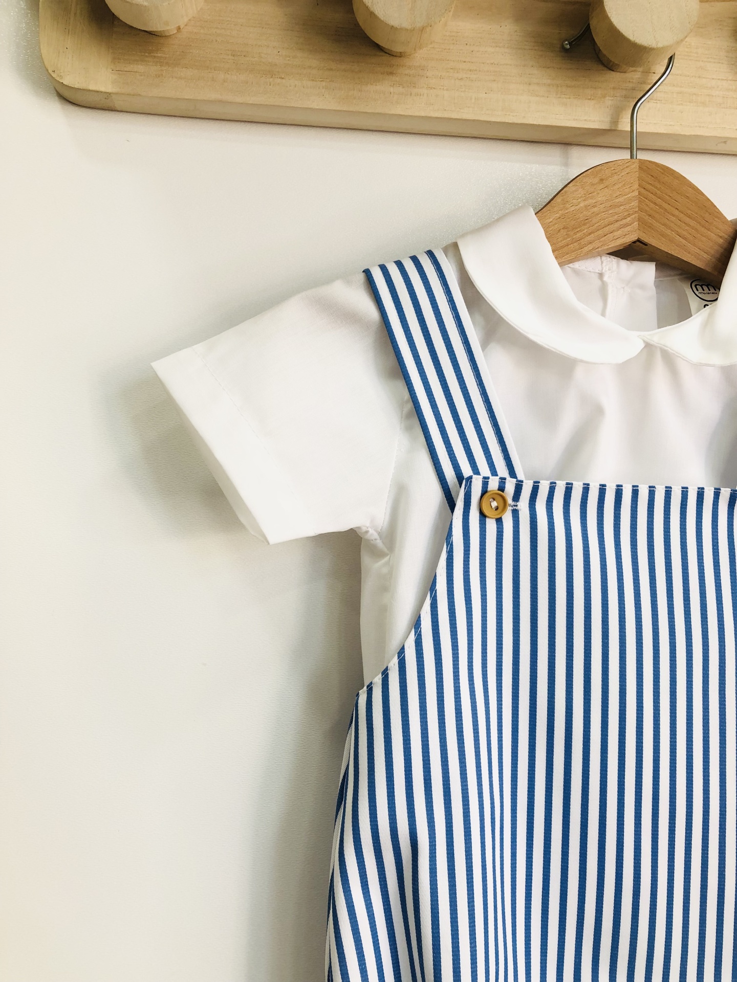 Conjunto infantil com camisa branca e jardineira riscada azul e branca