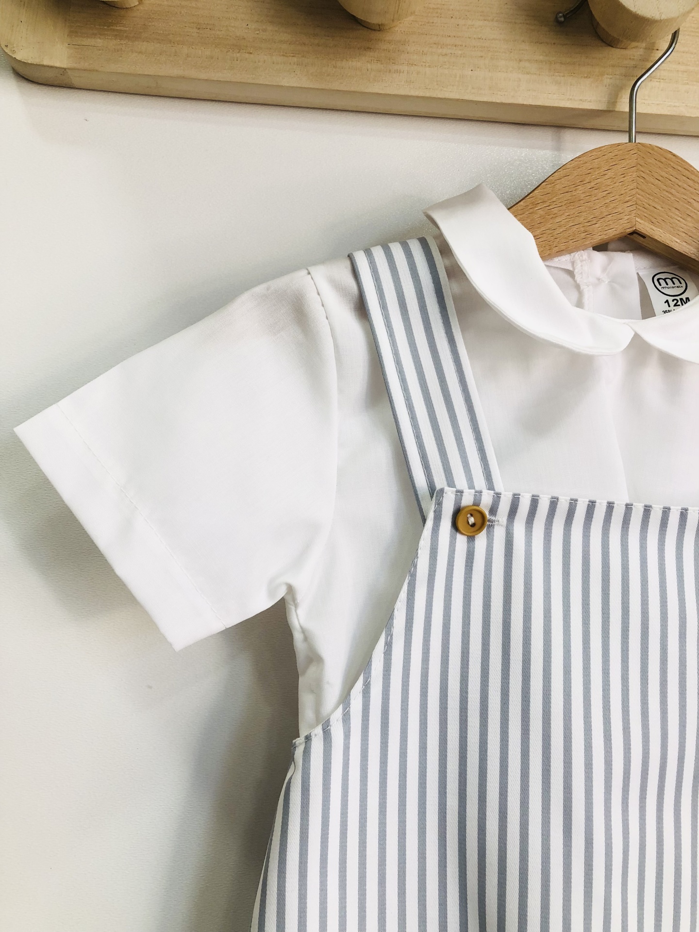 Roupa de criança com camisa branca e roupa de riscas azuis e brancas