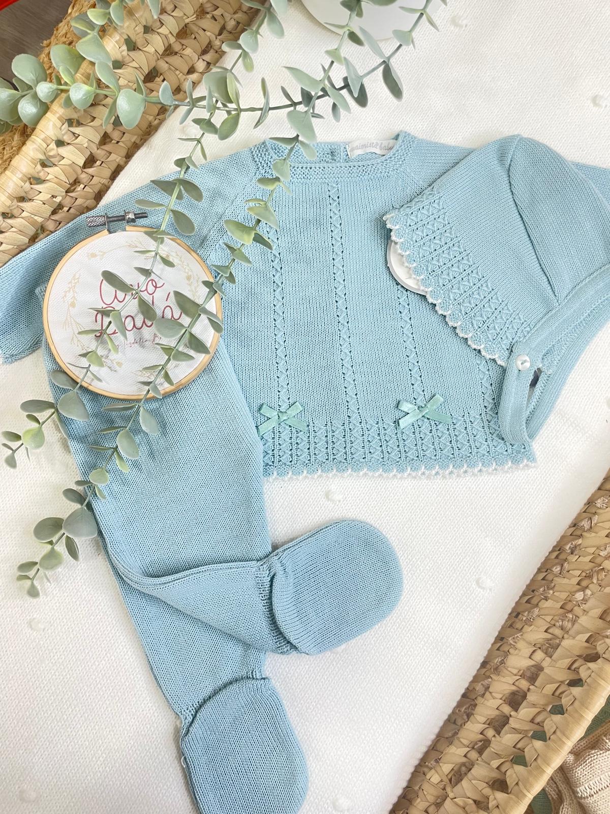 Conjunto de bebé em malha azul clara com casaco, calças e gorro decorativo