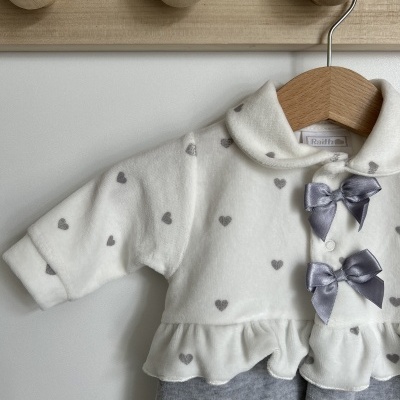 Macacão de bebé branco com corações cinzentos, laços cinzentos e parte inferior cinzenta pendurado em cabide de madeira