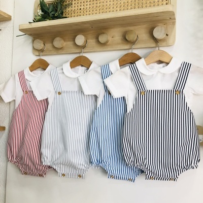 Macacões de bebé às riscas pendurados em cabideiro de parede