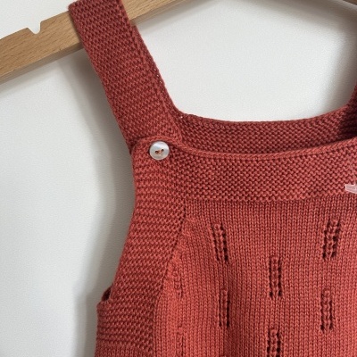 Vestido de malha vermelho tijolo com padrão e alças largas em cabide de madeira