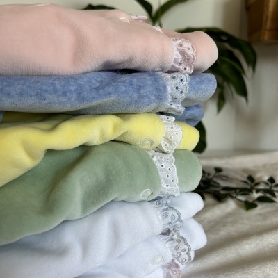 roupa de bebé em várias cores suaves com rendas e botões
