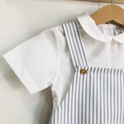 Roupa de criança com camisa branca e roupa de riscas azuis e brancas