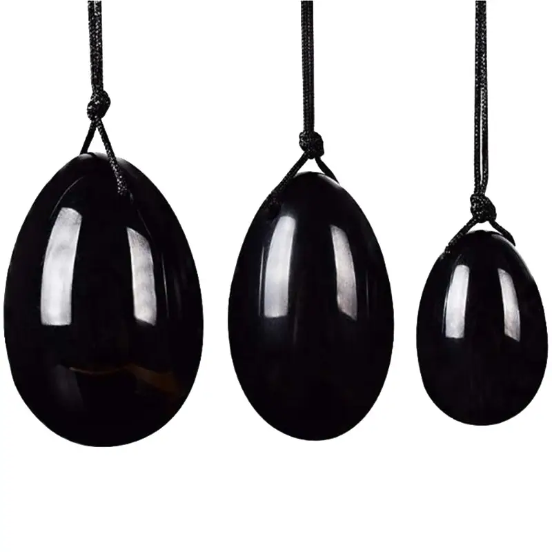 Três ovos negros brilhantes pendurados em cordões pretos