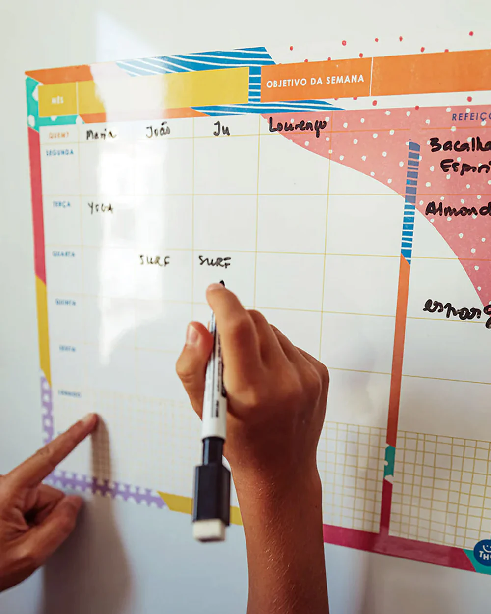 Quadro semanal branco para organização com textos escritos à mão a negro e bordas coloridas