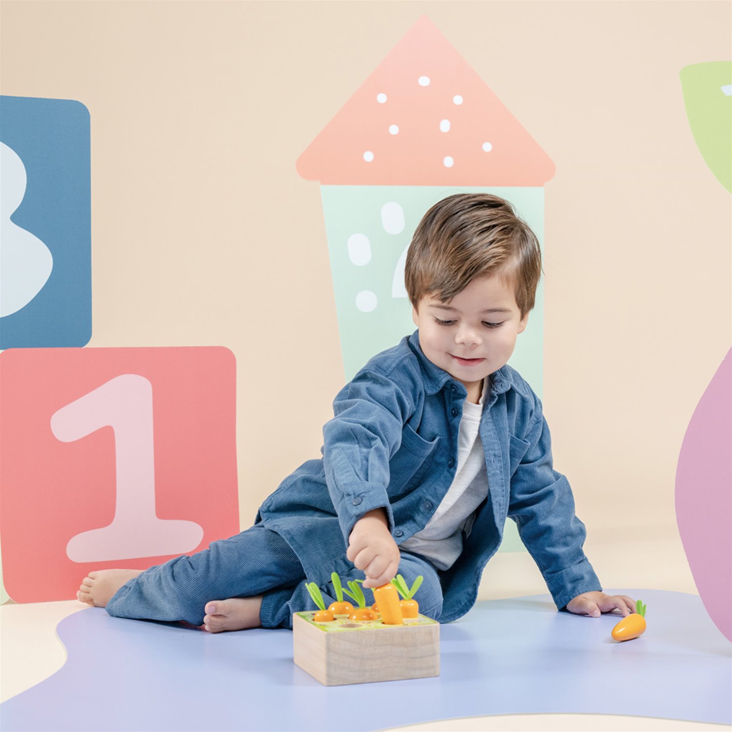 Menino com roupa azul brinca com brinquedo de madeira colorido em ambiente com decoração colorida com números.
