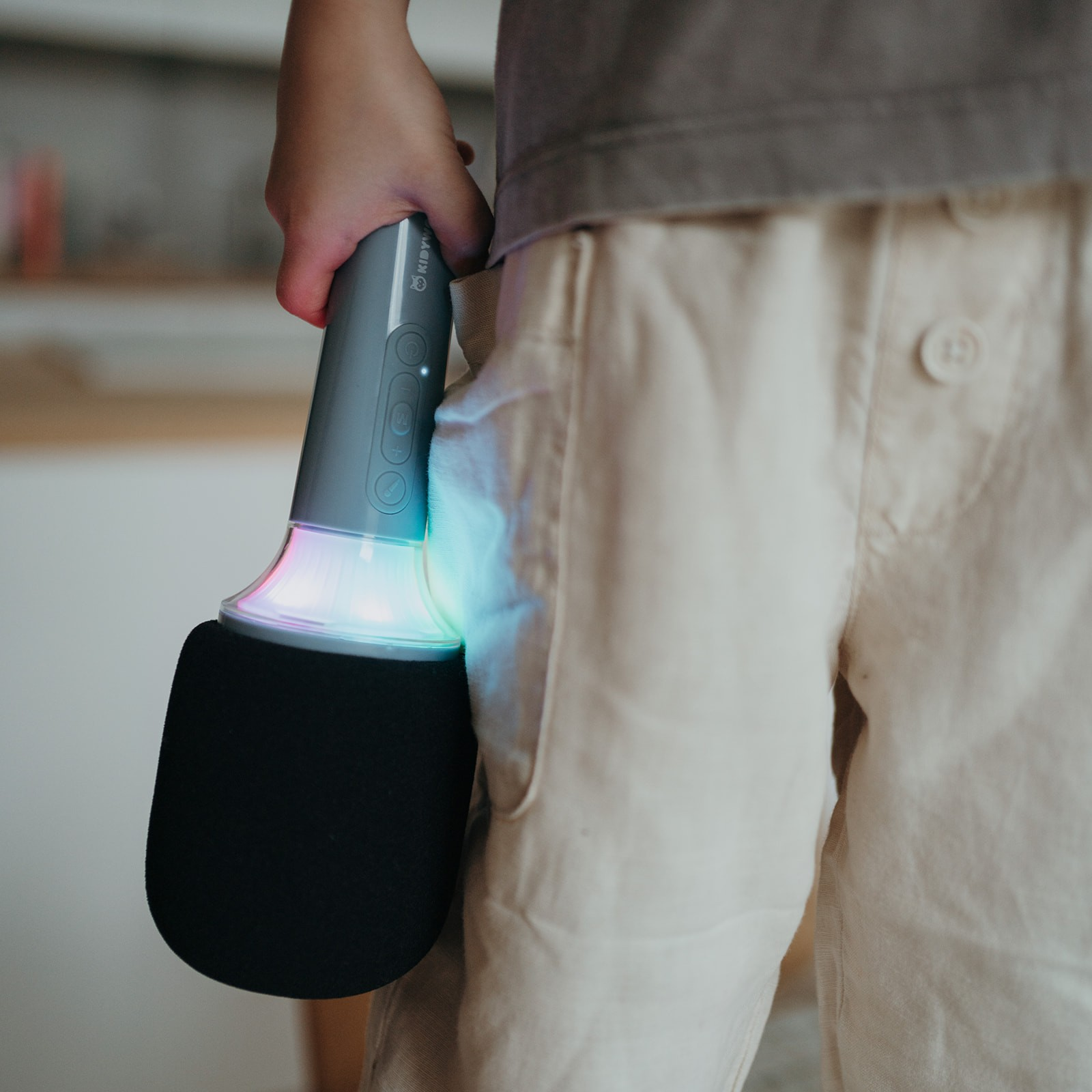 Microfone portátil com luzes LED coloridas sendo segurado por uma pessoa
