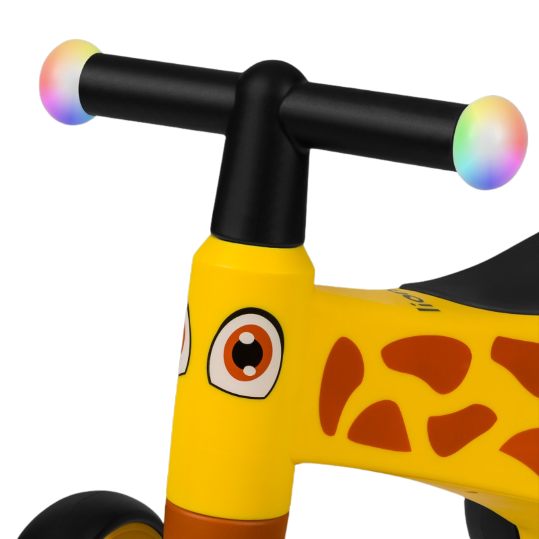Bicicleta infantil amarela com padrão de girafa e guiador preto com pontas coloridas