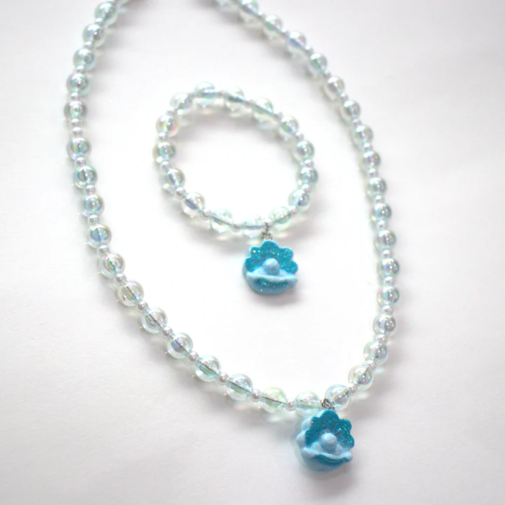 Conjunto de bijuteria com colar e pulseira de contas transparentes com pendentes de conchas azuis e pérolas brancas.