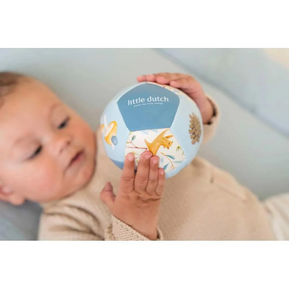 Bebé segurando bola macia colorida com texto little dutch