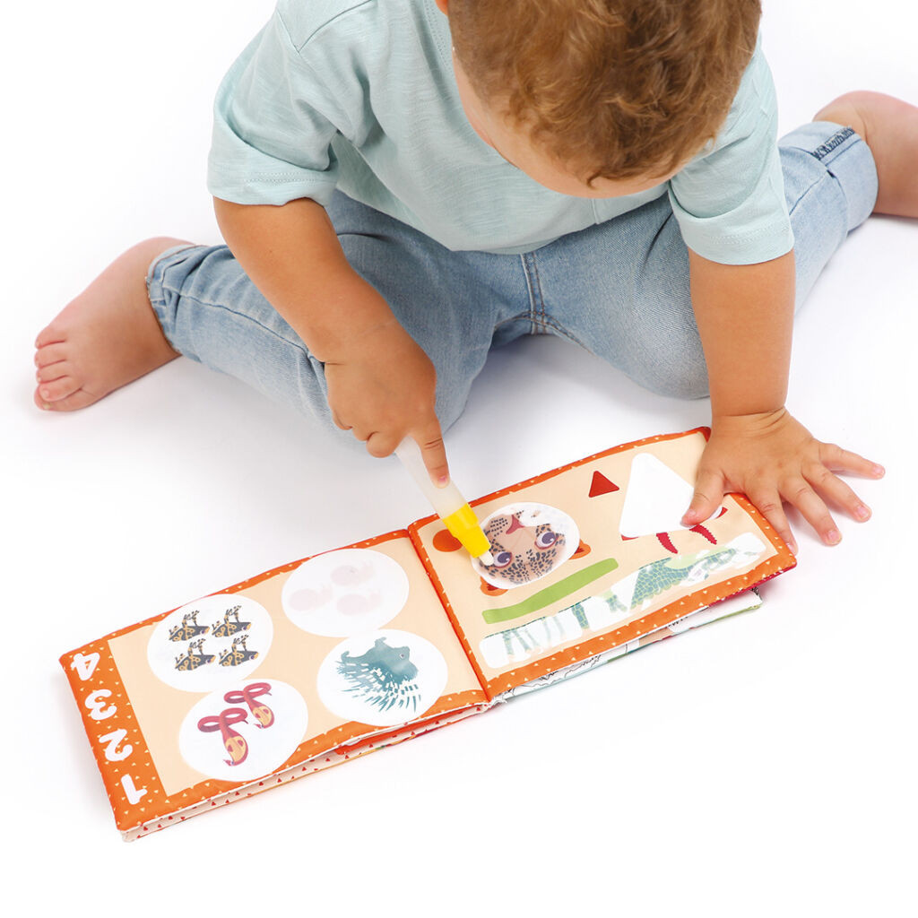 Bebé a brincar com livro infantil de tecido com números e imagens coloridas