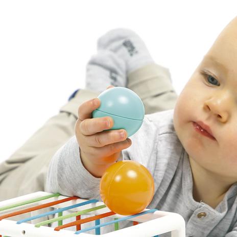 Bebé a brincar com bolas coloridas e brinquedo educativo