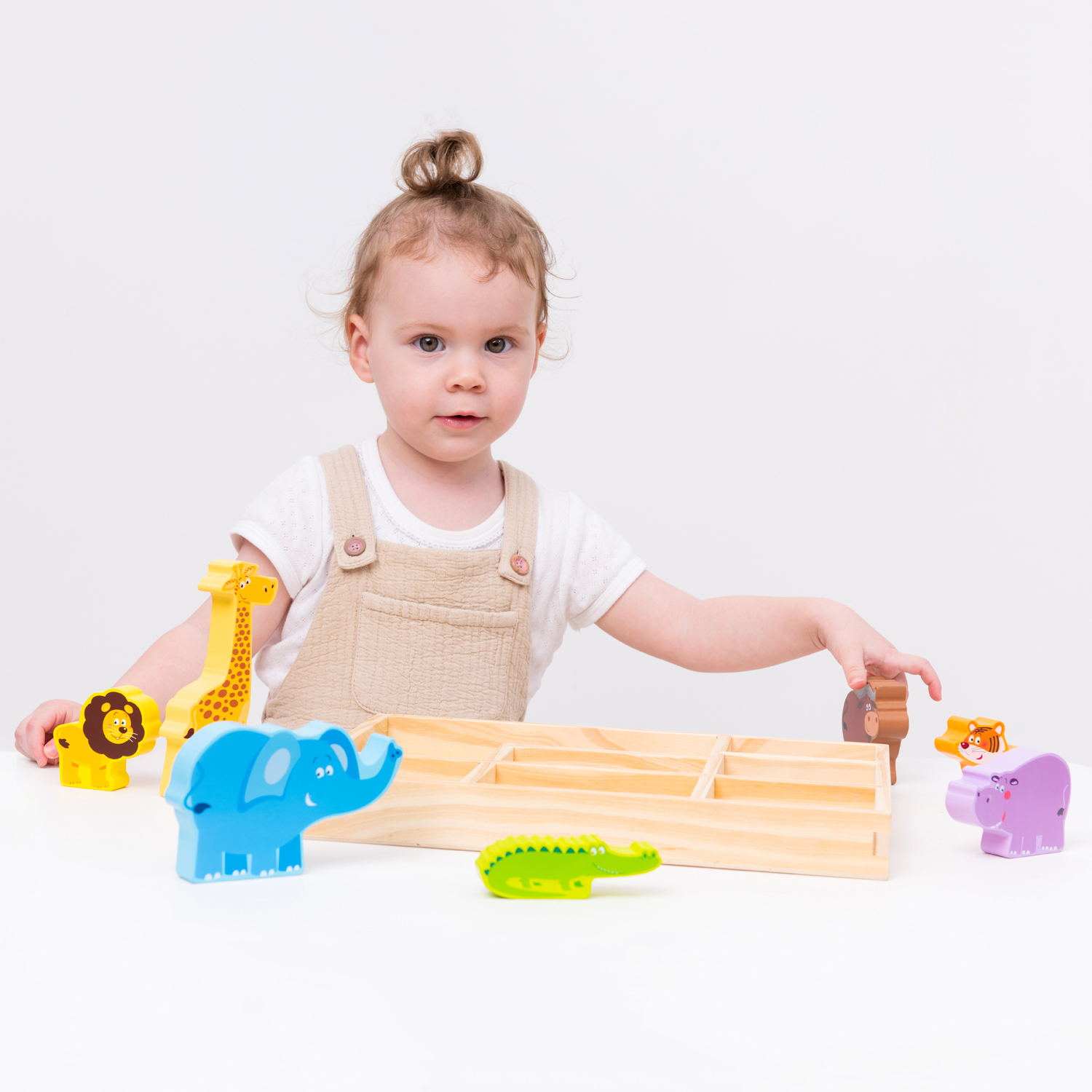 Criança com brinquedos de madeira coloridos e tabuleiro