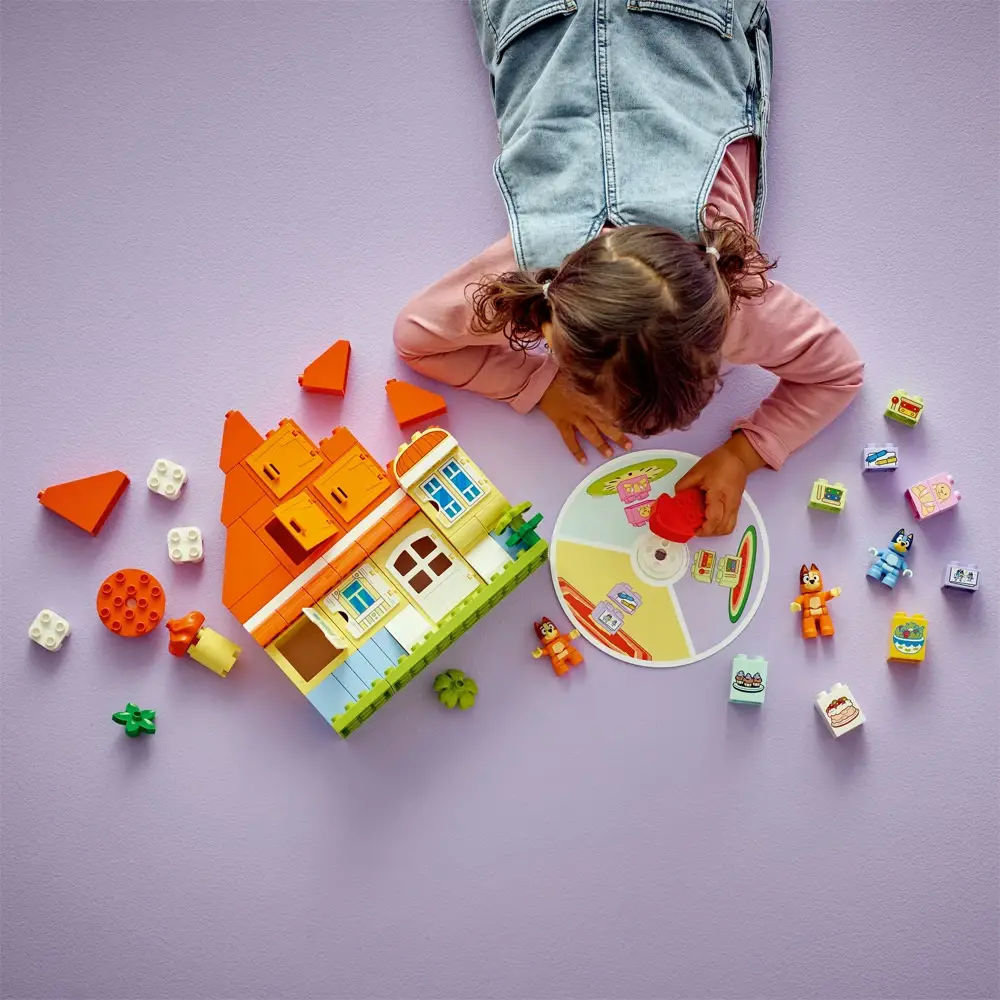 Criança a brincar com blocos de construção coloridos em fundo lilás