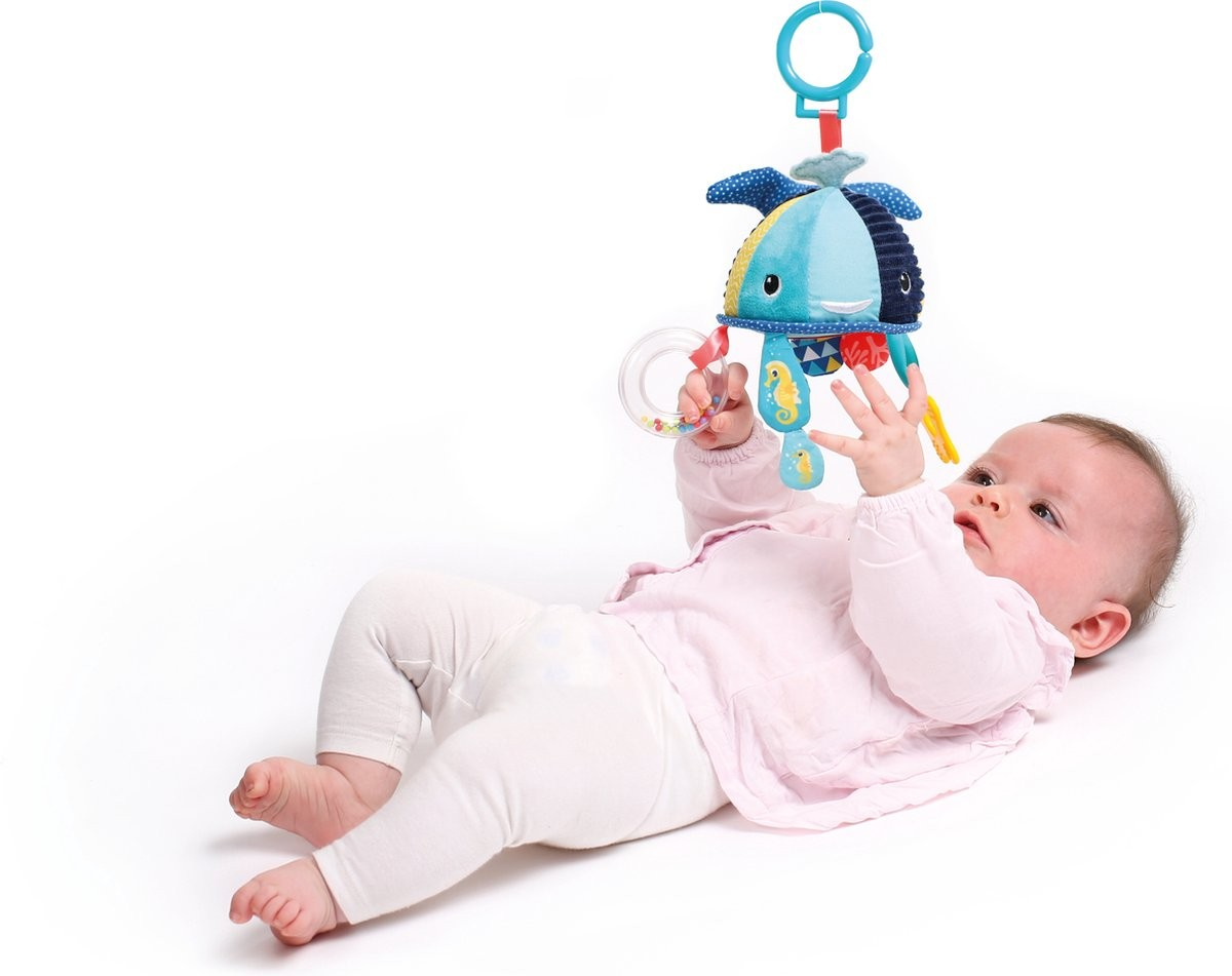 Bebé deitado a brincar com brinquedo pendurado colorido