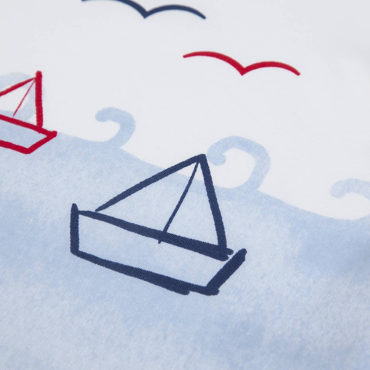 tecido branco com barcos desenhados e ondas azuis