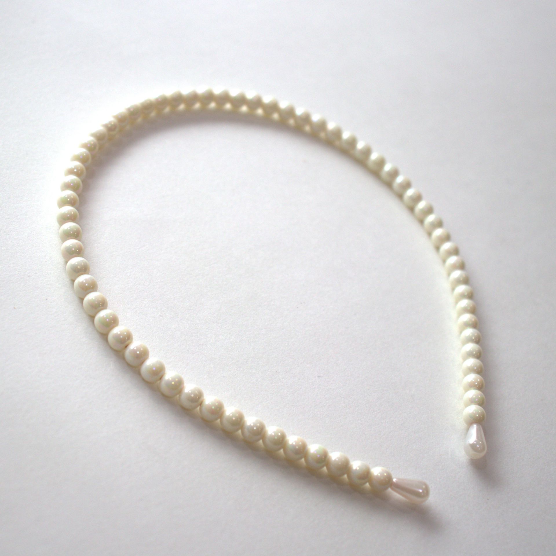 Aro de cabelo com pérolas brancas e pontas em plástico