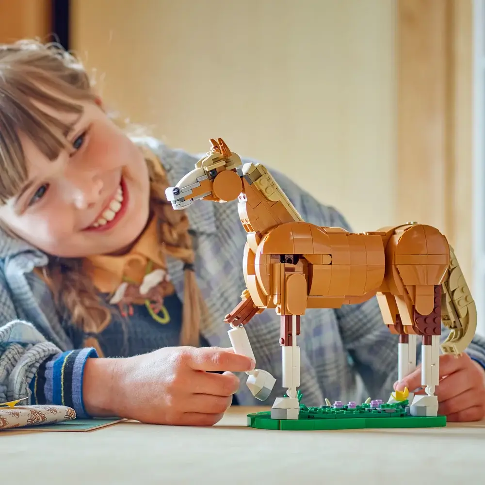 Figura de cavalo feita com peças tipo LEGO com criança ao fundo