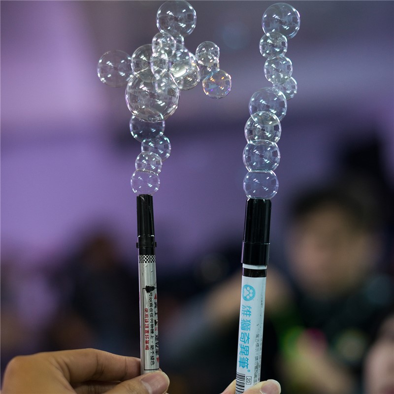 Dois bastões lançadores de bolhas de sabão com bolhas transparentes no topo