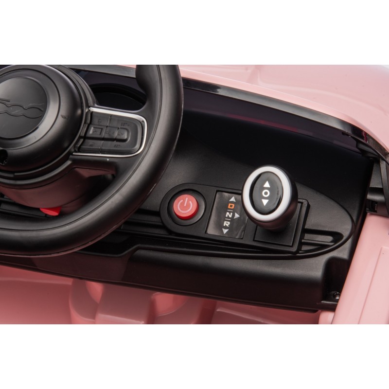 Painel de controlo com volante, botão vermelho e seletor num carro de brincar rosa