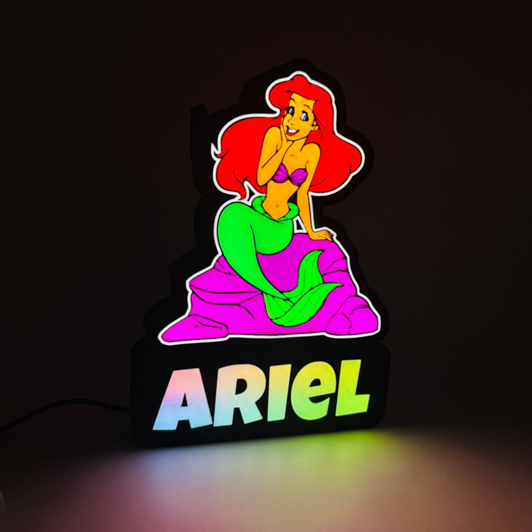 Luminária decorativa Ariel com letras coloridas num fundo negro.