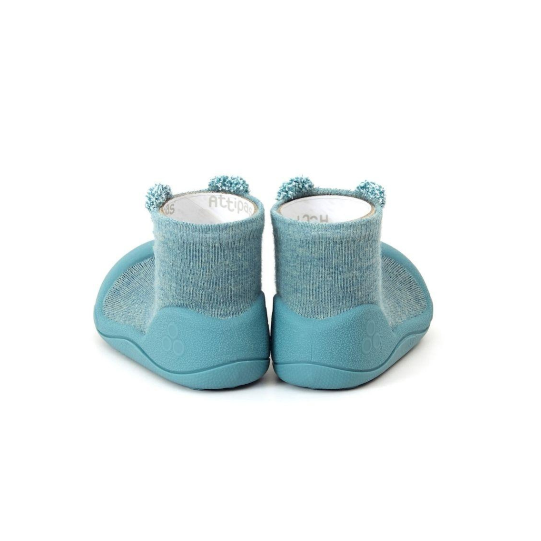Sapatilhas azuis para bebé com sola de borracha e parte superior tipo meia com pompons